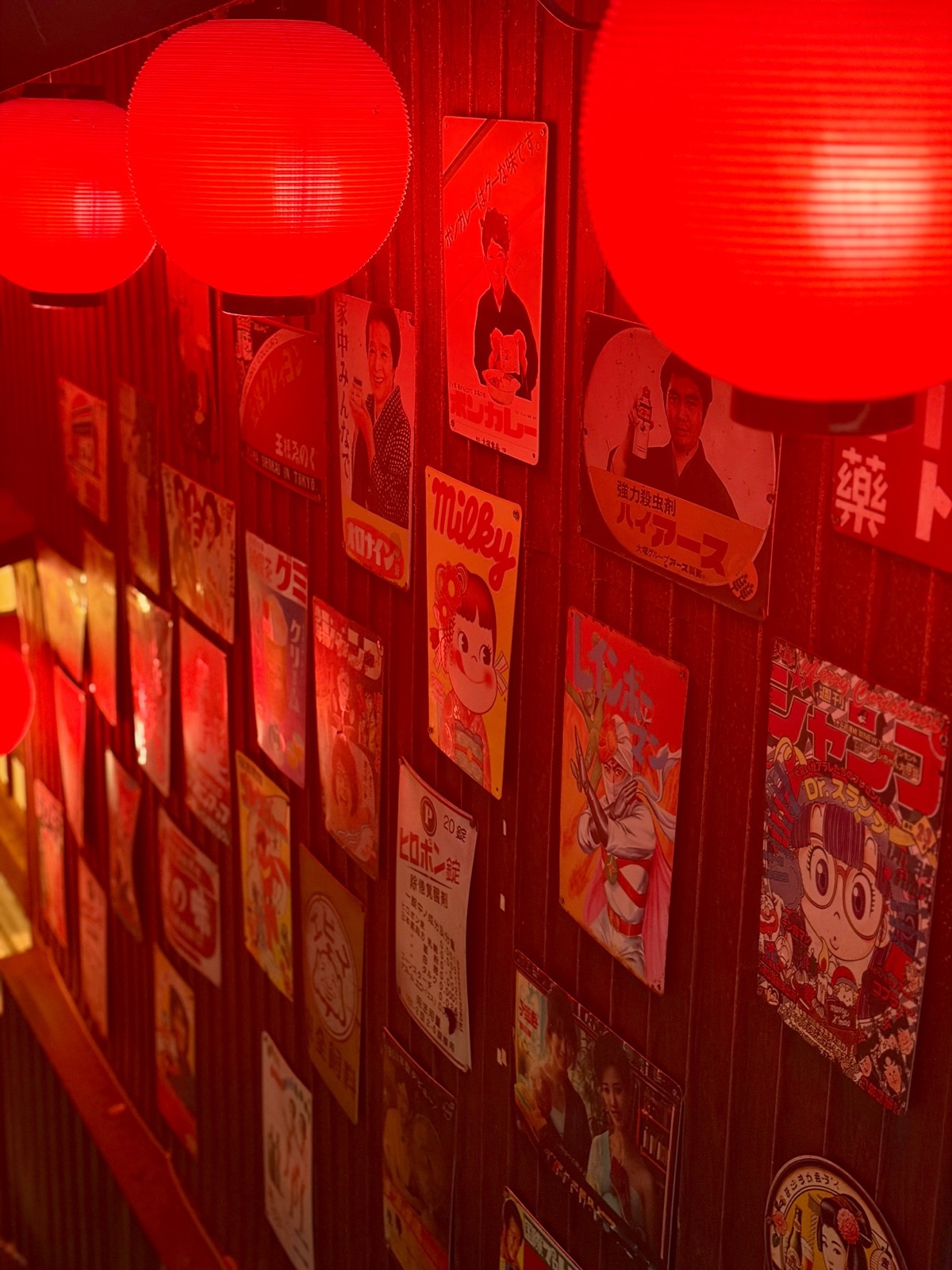 Red lanterns lighting a wall of posters