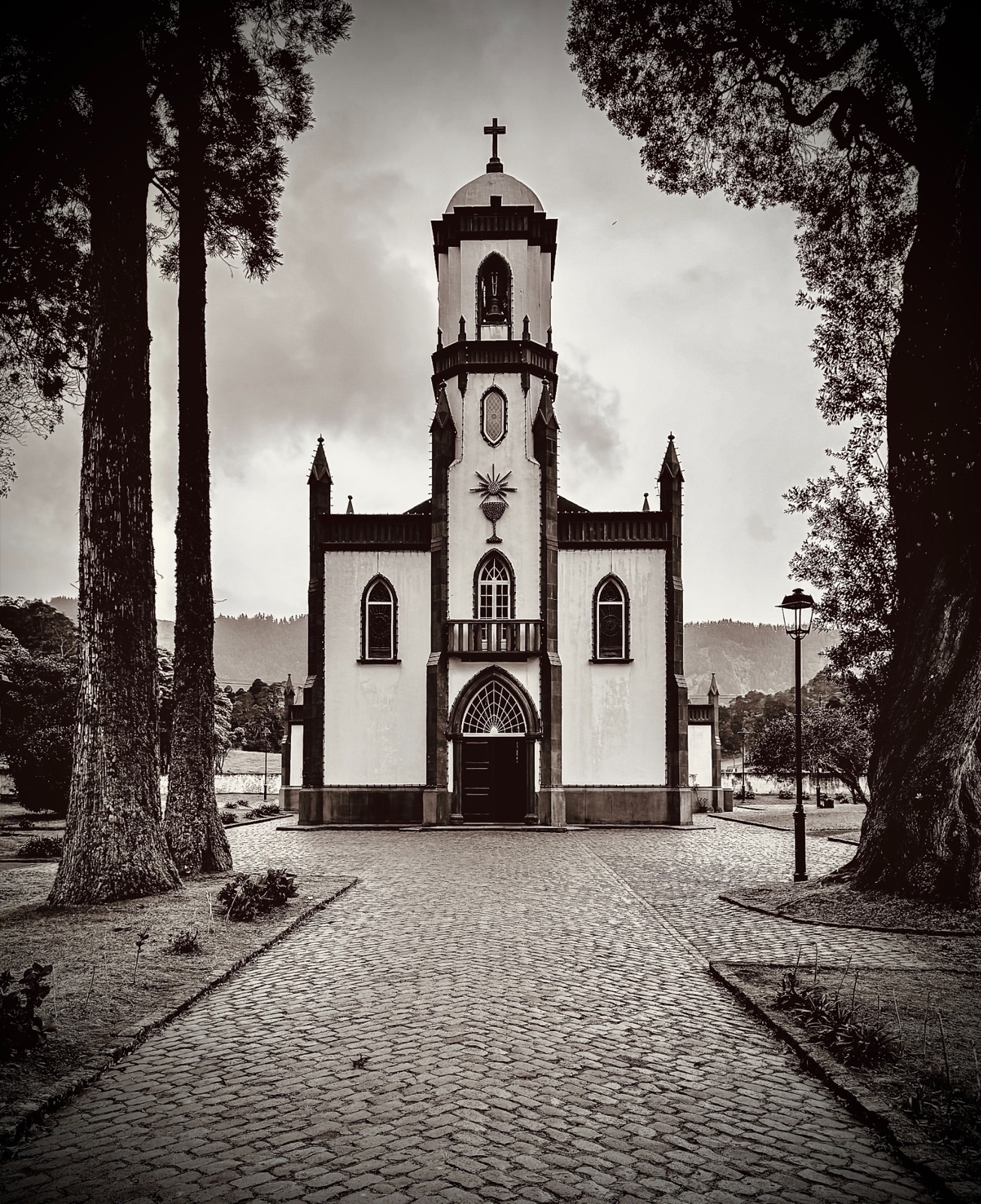 Black-and-white church framed by trees