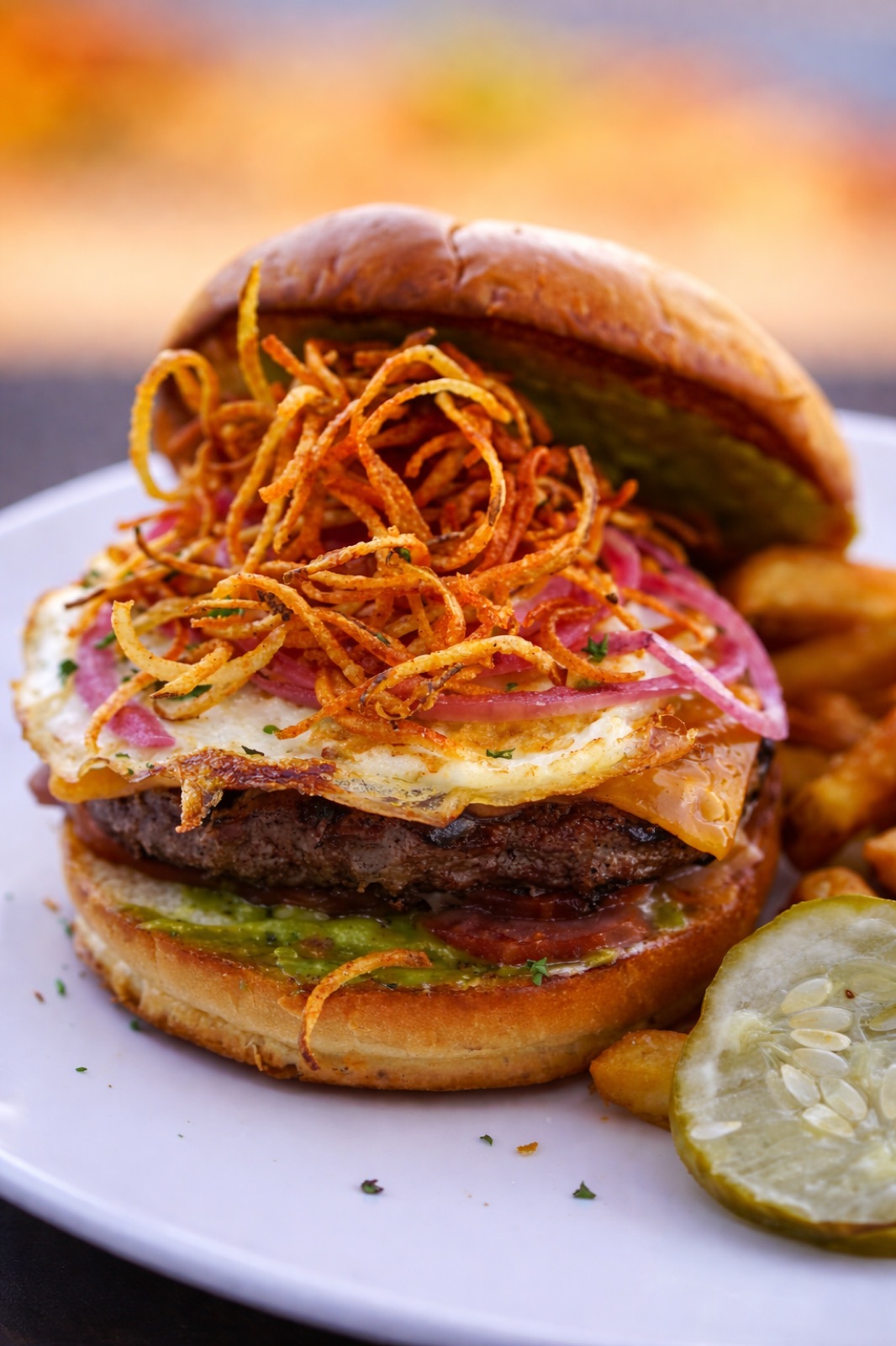 A stacked burger topped with crisp onions