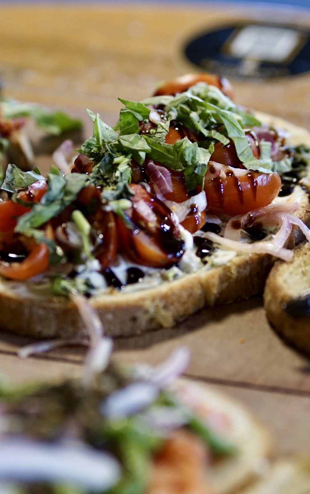 Toasts topped with tomatoes, fresh basil, red onions and a dark glaze